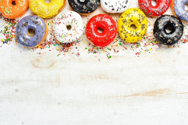 Set of sweet colored donuts on a white wooden background Top view Flat Lay