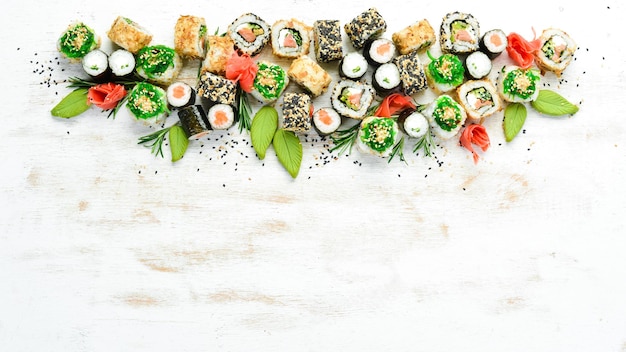 Set of tasty sushi and maki rolls on white wooden background Japanese food Top view Free space for your text