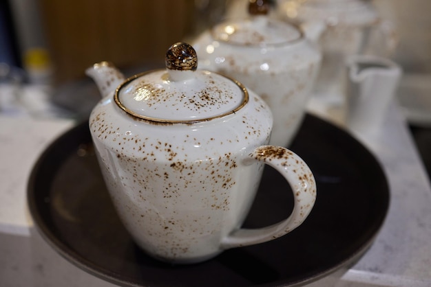 A set of teapots with small cups that are unique and classic