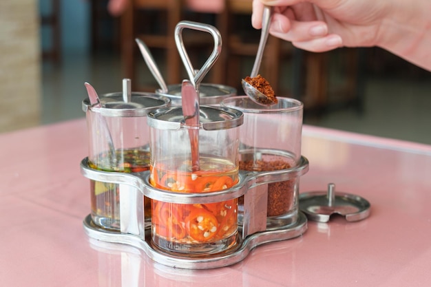 Set of Thai spices in glass jars on a table in a cafe