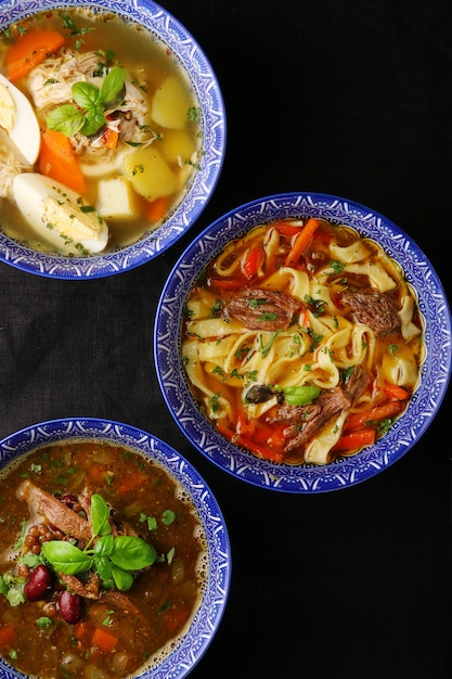 Set of three soups top view on dark background