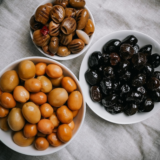 A set of three types of olives in white bowls