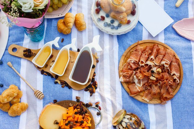 Set of three white sauceboats with sweet honey on wooden tray