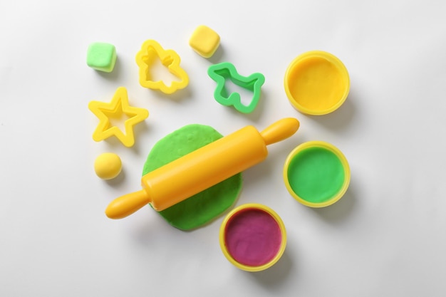 Photo set of tools and color play dough on white background top view