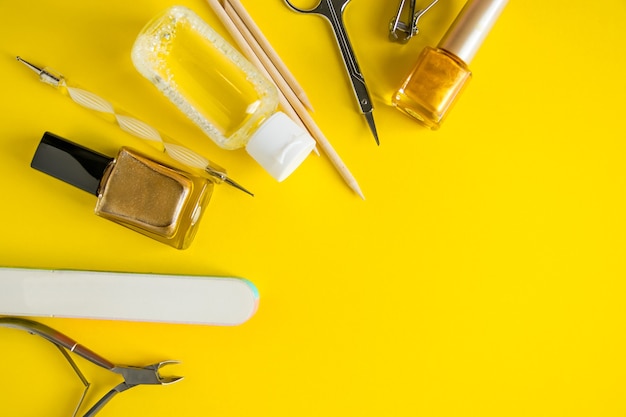 Set of tools for manicure and nail care on a yellow background. Place for text.