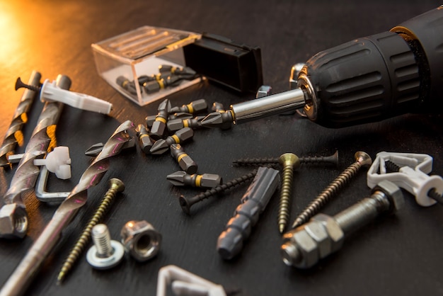 Set of tools on the table, a screwdriver with a set of drill bits and screws with bolts. all for repair