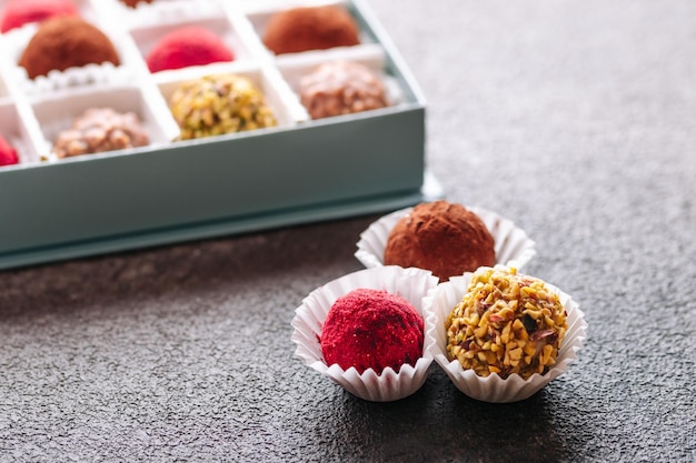 A set of truffle sweets with different fillings on a brown background