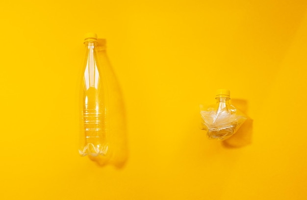 Set of two empty plastic bottles full and crumpled collage isolated on yellow background