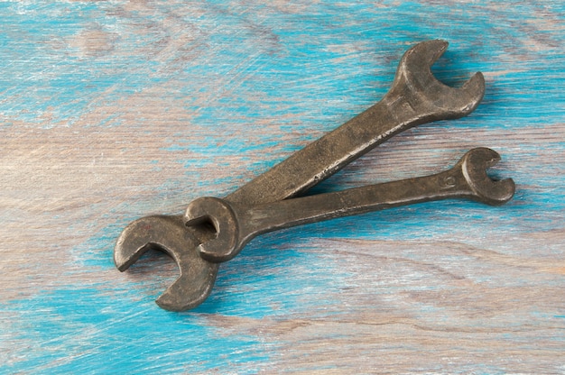 Set of two vintage bronze wrench on shabby blue wooden background. Copy space for text.