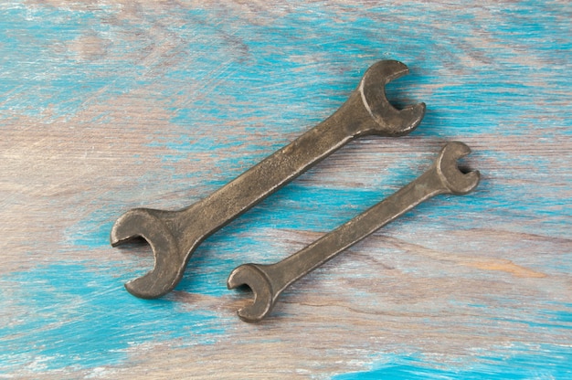 Set of two vintage bronze wrench on shabby blue wooden background. Copy space for text.