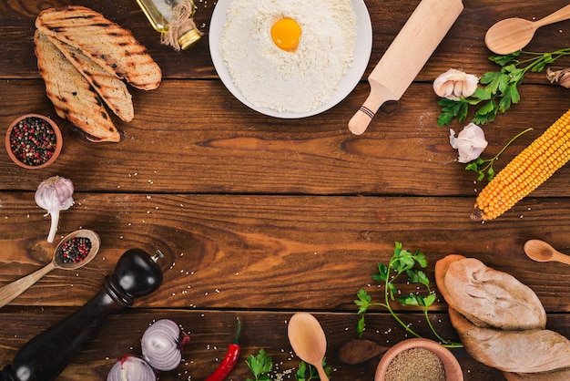 Set of Ukrainian cuisine Vareniks fresh vegetables spices Top view On a wooden background Copy space