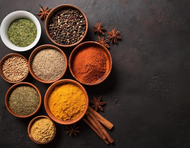 Set of various spices and herbs on black slate background Pepper