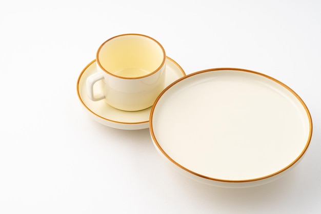 A set of white and brown ceramic plate and cup on a white background