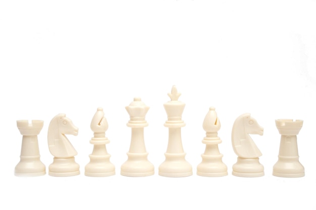 Set of white chess pieces are lined up isolated on a white background.