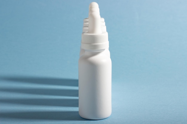 A set of white cosmetic bottles with a dropper lined up with hard shadows The concept of face and body care at home and in a beauty salon