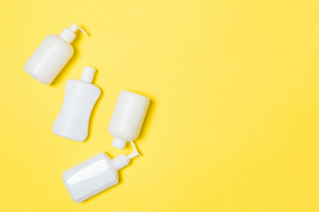 Set of White Cosmetic containers on yellow background with copyspace