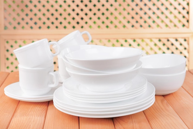 Set of white dishes on table on light background