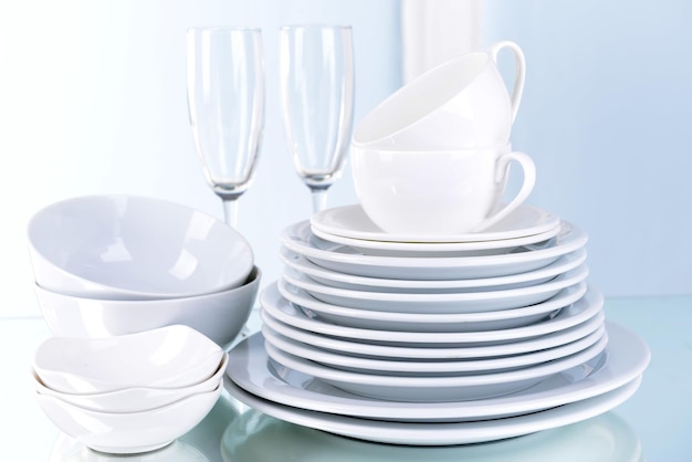 Set of white dishes on table on light background