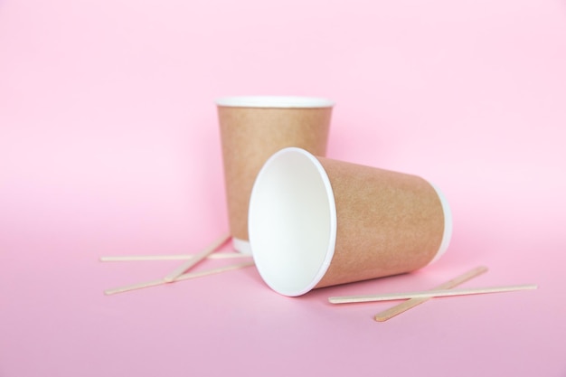 Set with disposable environmental paper utensils on pink background