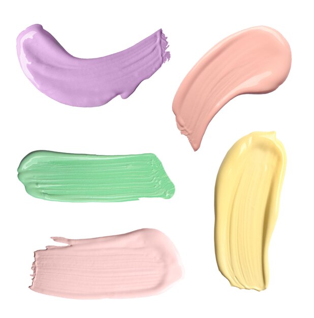 Set with strokes of color correcting concealers on white background top view