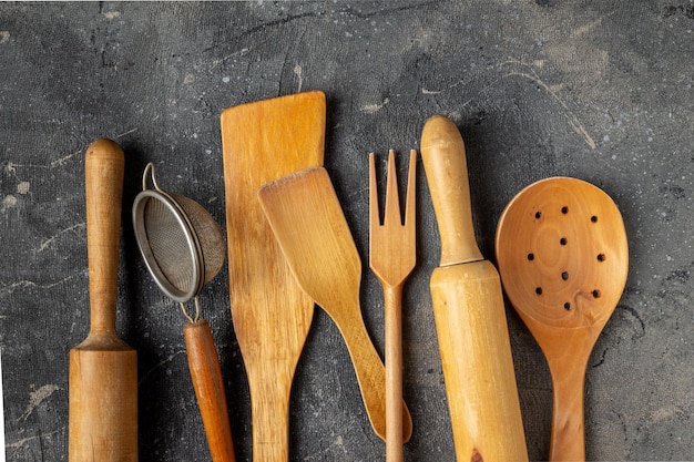 Set of wooden kitchen utensils on a blue background closeup