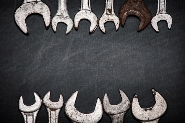 Photo set of wrenches with empty space on a dark textured background, made for text or brand.