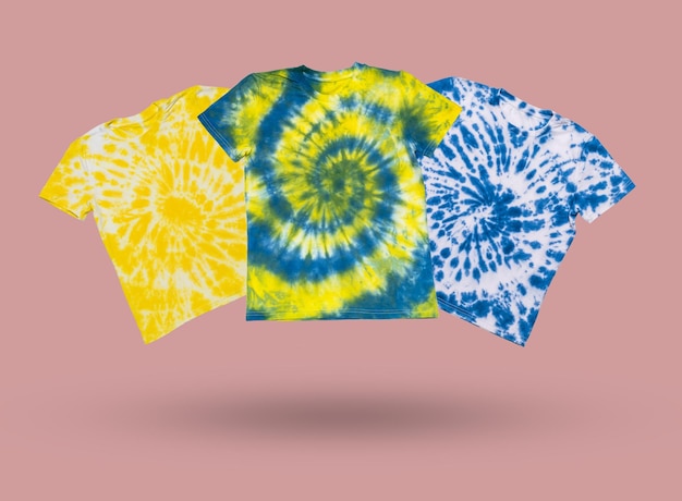 A set of yellow and blue tie dye Tshirts on a pink background