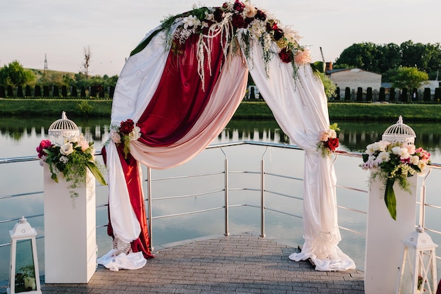 Setup wedding ceremony on pier Wedding arch decorated with flowers Wedding atmosphere scenery celebration Photography concept