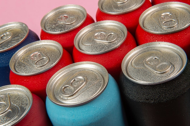 Several aluminum soda cans in assorted colors in a table