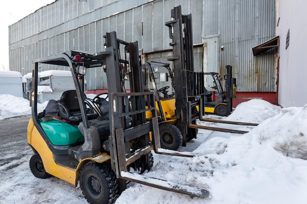 Several forklifts stand near the warehouse building