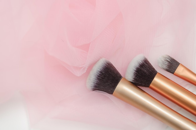 Several makeup brushes on a light pink background aesthetics of makeup artist makeup holiday birthday beauty salon content shooting for makeup artist