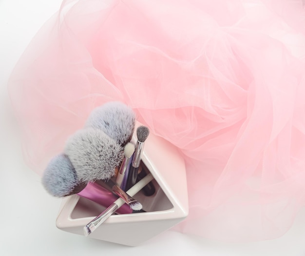 Several makeup brushes on a light pink background aesthetics of makeup artist makeup holiday birthday beauty salon content shooting for makeup artist