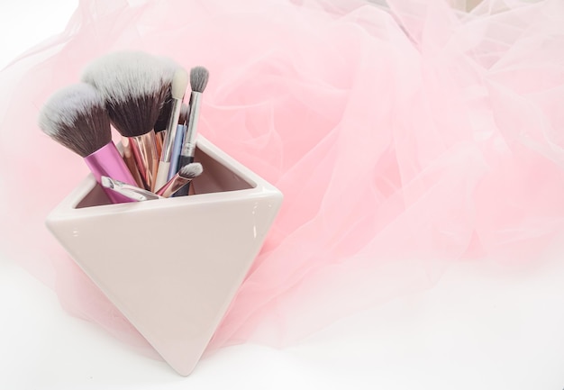 Several makeup brushes on a light pink background aesthetics of makeup artist makeup holiday birthday beauty salon content shooting for makeup artist