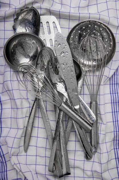 several metal kitchen utensils on a kitchen towel