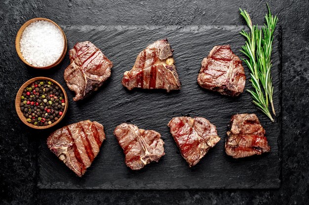 several mini Grilled beef T-Bone steaks on stone table