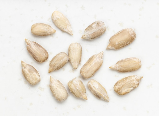 Several peeled sunflower seeds close up on gray