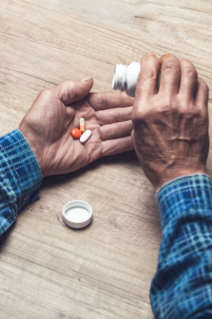 Photo several pills in the hands of an elderly person