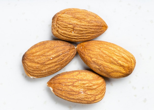 Several raw almond seeds close up on gray