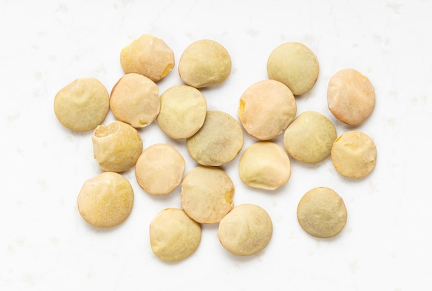 Several raw light green lentils close up on gray