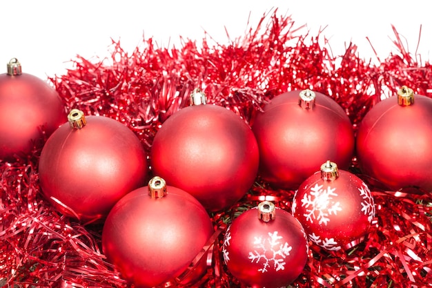 Several red Christmas baubles and tinsel isolated