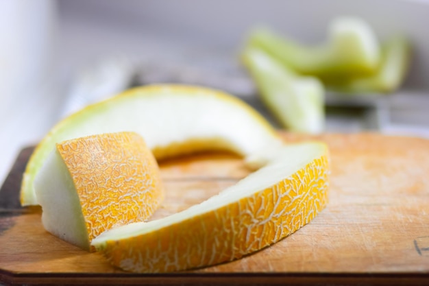 Several slices of melon on a blurred background closeup Juicy ripe melon slices on wooden board with blurred background