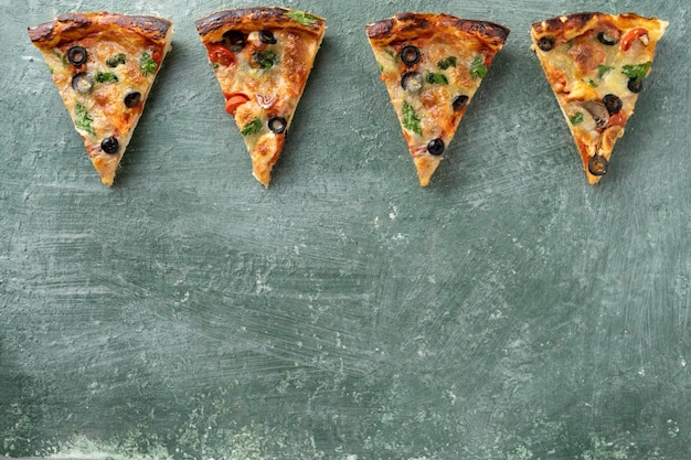 Several slices of pizza on a green background