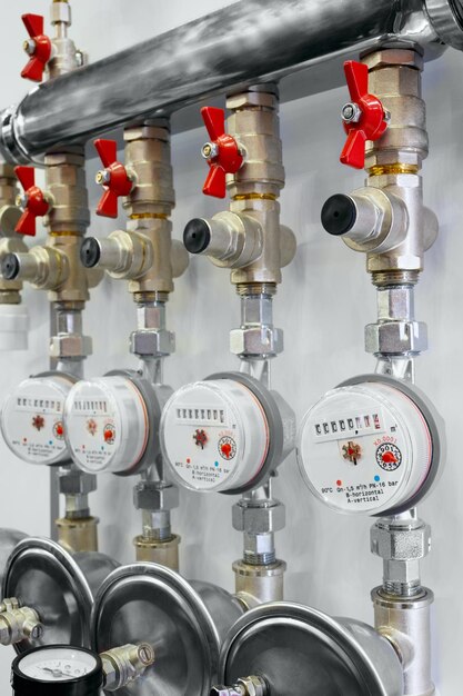 Several water meters Measurement and brass distributor with red valves of water flow