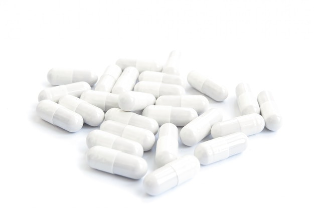 Several white pills on a white background