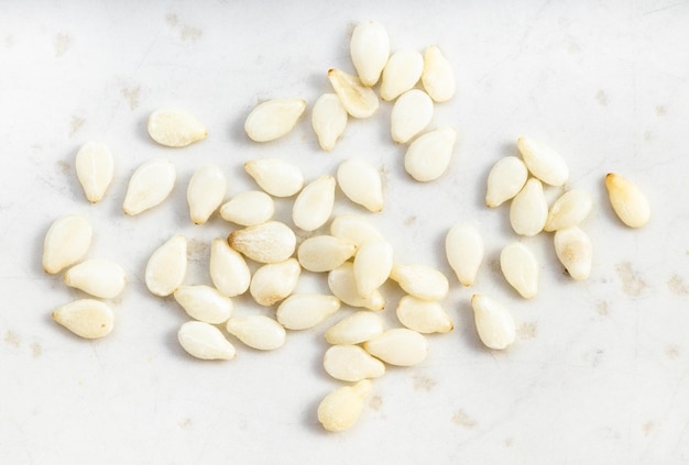 Several white sesame seeds close up on gray