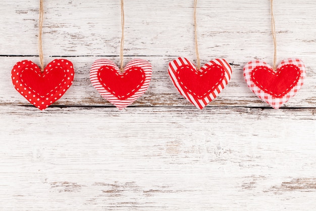 Sewed Pillow Hearts Row Border from Red Fabric at Rustic White Wood Background