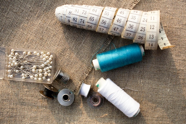 Sewing accessories. Measuring tape, needles, colored threads, thimble. The concept of hobby.