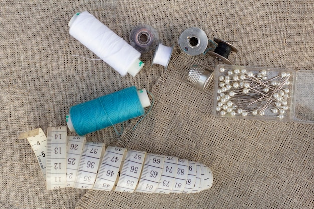 Sewing accessories. Measuring tape, needles, colored threads, thimble. The concept of hobby.