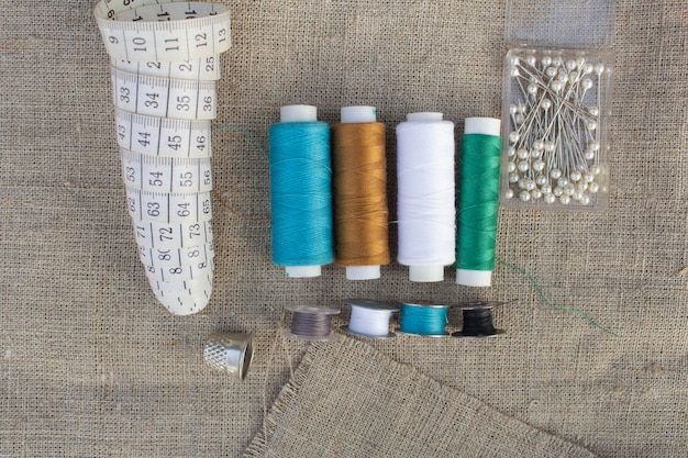 Sewing accessories. Measuring tape, needles, colored threads, thimble. The concept of hobby.