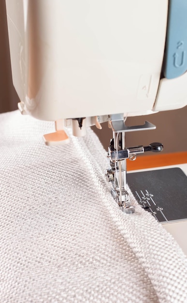 Sewing machine the process of sewing a decorative cord of white fabric